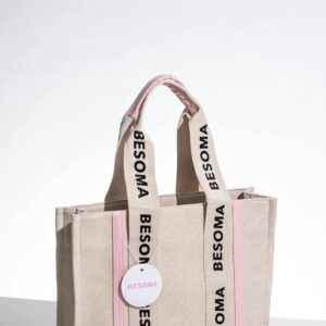 Home Elegant beige handbag with pink accents, perfect for fashion and shopping enthusiasts.