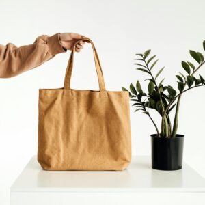 Home Stylish minimalist canvas tote bag held beside a potted green plant.